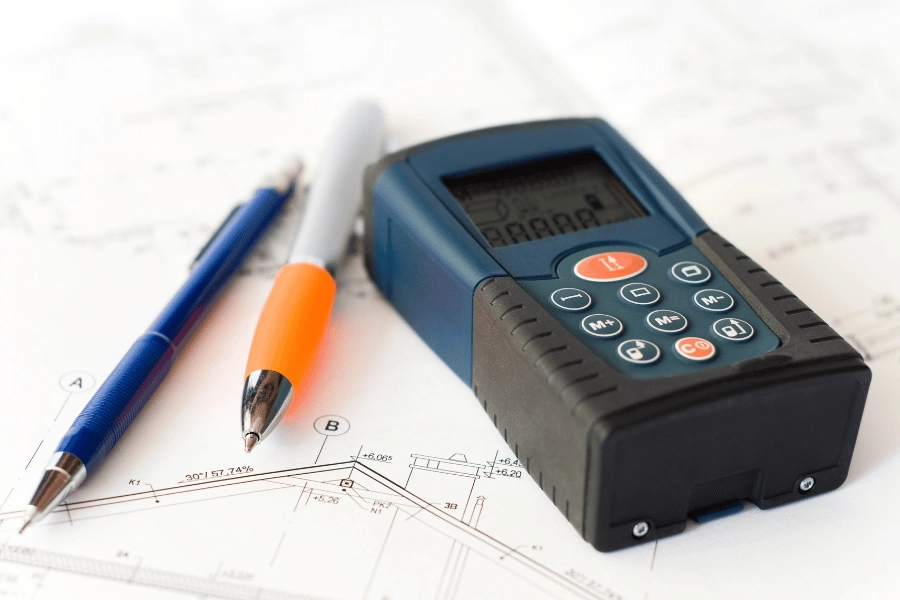 laser distance measurer sitting on top of house plans